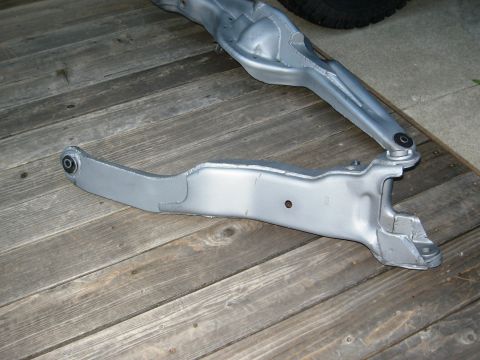 1986 Ford Bronco - Close-up of vehicle suspension components laid out on a wooden surface.