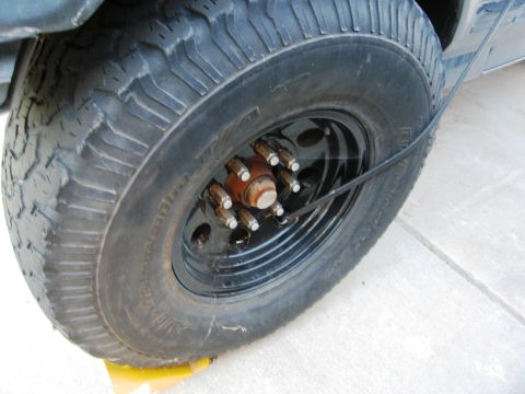 1986 Ford Bronco - A close-up view of a BFGoodrich tire mounted on a black wheel, showing the lug nuts and hub.