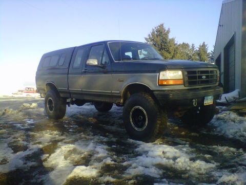 1994 Ford F-150 - This 1994 Ford F-150 pickup truck is equipped with a camper shell and lifted suspension.
