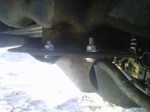 1994 Ford F-150 - Close-up view of the undercarriage, showing bolted components and suspension elements. The Supermotors.net logo is present in the lower rig…