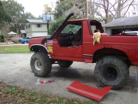 1986 Ford Bronco - This red 1986 Ford Bronco is modified for off-roading with a snorkel and has had its doors removed.