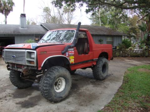 1986 Ford Bronco - This modified Ford Bronco features a snorkel and large off-road tires, suggesting it's built for terrain.