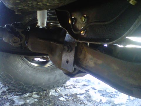 1994 Ford F-150 - Undercarriage view of a 1994 Ford F-150, highlighting suspension parts and a tire.
