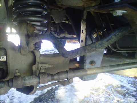 1994 Ford F-150 - Close-up view of the front suspension and steering linkage on a 1994 Ford F-150 pickup truck.