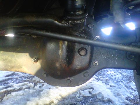 1994 Ford F-150 - The rear differential assembly of a vehicle is shown in this close-up shot with snow on the ground.