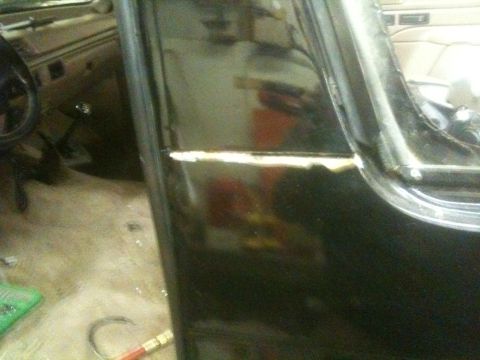 1993 Ford Bronco - The interior of a vehicle is visible, with a focus on the door frame and a portion of the dashboard and steering wheel.