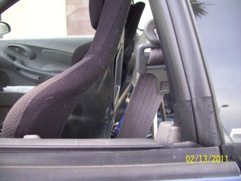 1995 Ford Probe - Close-up view of a car's interior, focusing on the driver's seat and seatbelt mechanism.