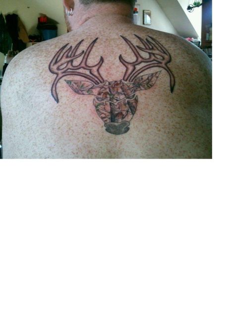 1993 Ford Bronco - A tattoo of a deer head with camouflage fill and prominent antlers is visible on a person's back.