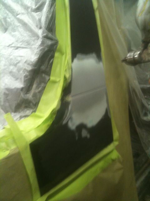 1993 Ford Bronco - A vehicle body panel is masked and prepped with primer, indicating bodywork is in progress.