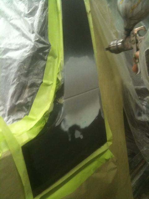 1993 Ford Bronco - Bodywork in progress: a car door is masked and being painted.