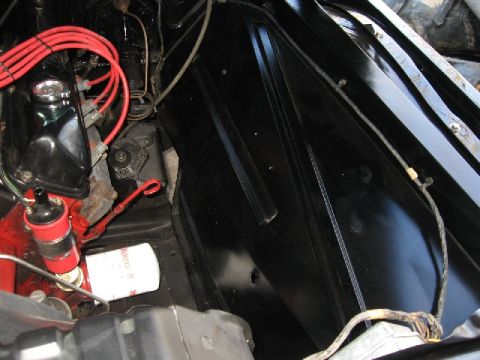 1966 Ford F-100 - A close-up view of engine components, including spark plug wires and an oil filter, in a vehicle's engine bay.