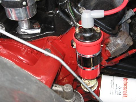 1966 Ford F-100 - Close-up of engine components including a red ignition coil and a Motorcraft oil filter.