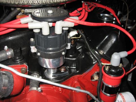 1966 Ford F-100 - Close-up view of a distributor and ignition coil assembly on a vehicle's engine.
