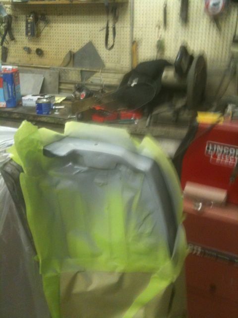 1993 Ford Bronco - A car part is being prepped for painting in a workshop environment.