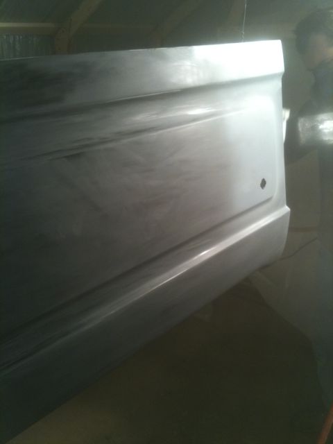1993 Ford Bronco - Unpainted vehicle tailgate with a small hole, viewed from the rear quarter.