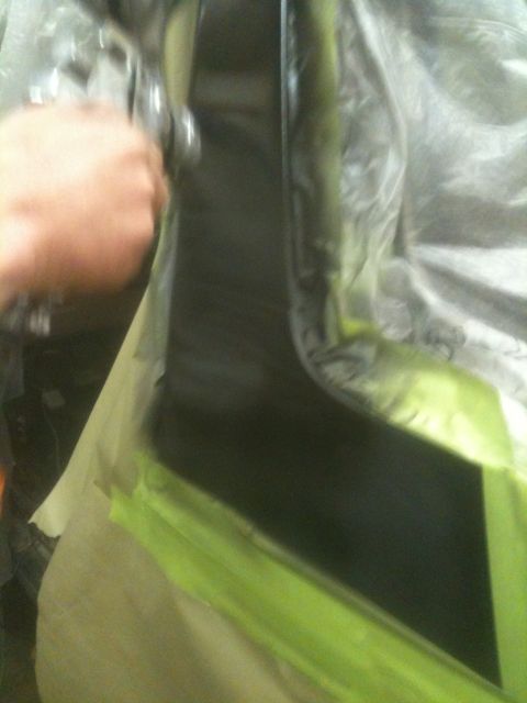 1993 Ford Bronco - Car body panel being painted with a spray gun, covered in masking tape.