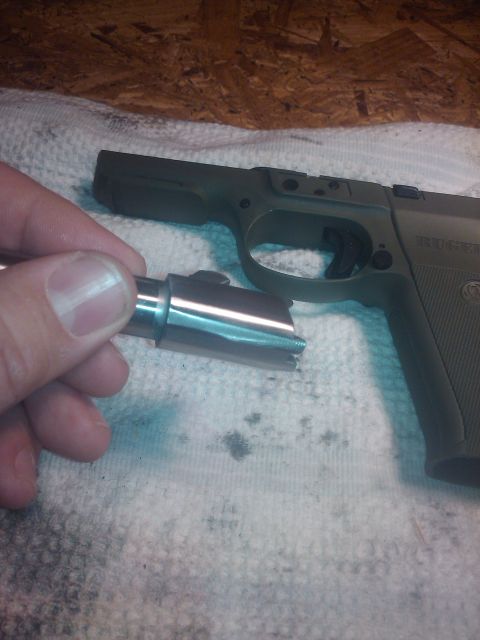 1989 Ford Bronco - A person's hand holds a pistol barrel next to the firearm's frame, showing the components disassembled.
