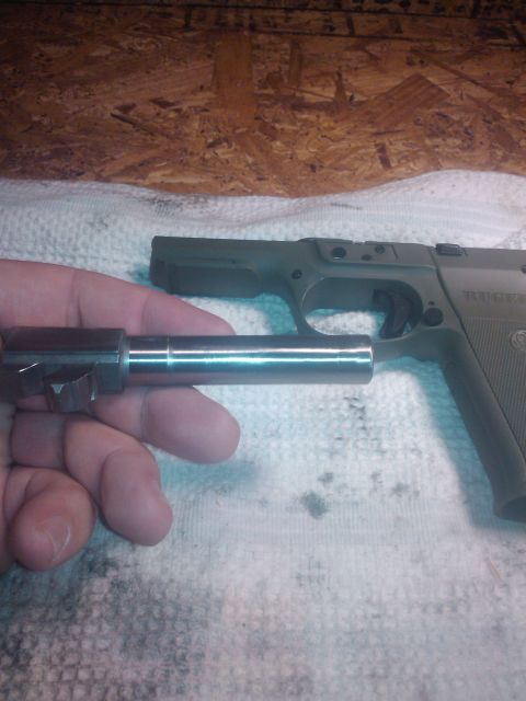 1989 Ford Bronco - A person is holding a disassembled pistol barrel over the pistol's frame.