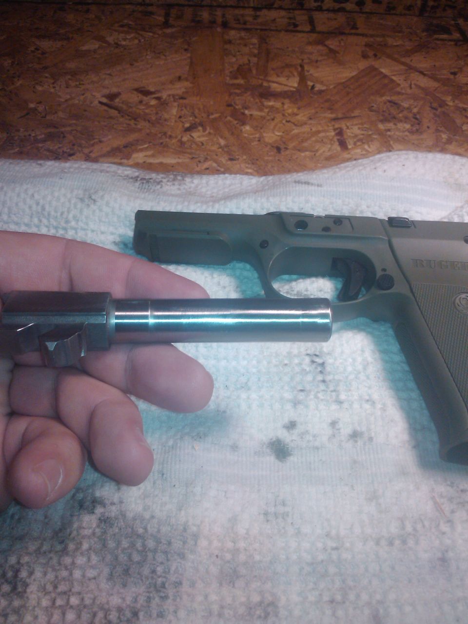 hand holding pistol barrel, frame in background