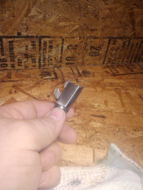 1989 Ford Bronco - A metal part is held in a hand in front of a wood-paneled surface.