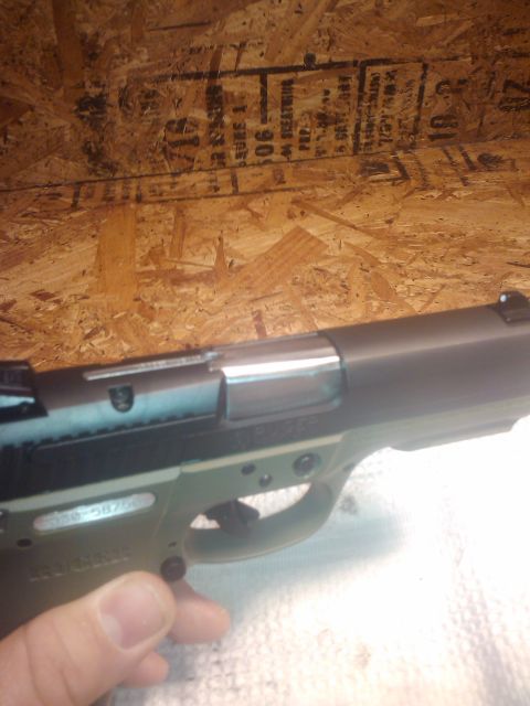 1989 Ford Bronco - A hand holds a pistol with visible markings and a serial number.