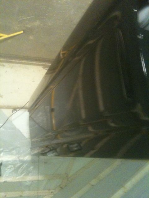 1993 Ford Bronco - Close-up view of a dark-colored vehicle's tailgate, showing reflections on its surface.