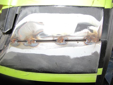 1993 Ford Bronco - Close-up of a vehicle tailgate undergoing repair with visible welding marks and masking tape.