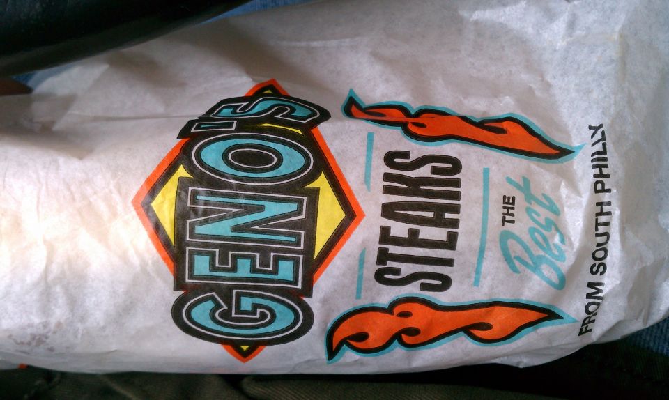 Geno's Steaks wrapper with orange flames and text reading "THE Best FROM SOUTH PHILLY"