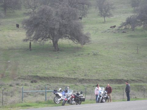 1991 Ford Bronco - A group of people and their motorcycles pause by the side of the road on a cloudy day.