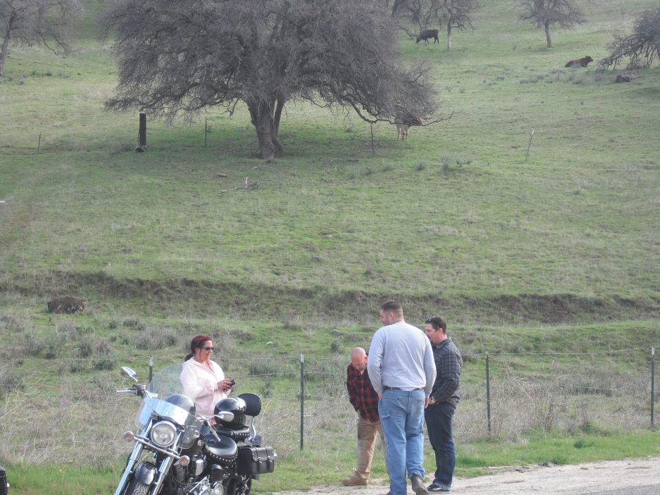 Motorcycle parked on roadside with people talking nearby