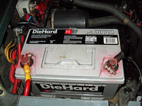 1990 Ford Bronco - A DieHard Platinum P-2 AGM battery installed in an engine bay, its white top labeled '930 CCA / 135 RC', with red and yellow cables clamped…