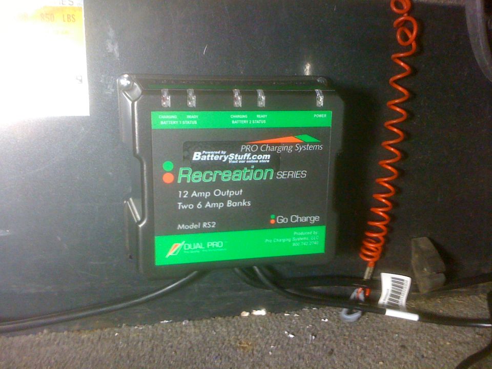 Dual Pro RS2 two-bank onboard charger mounted in boat compartment with coiled red cord