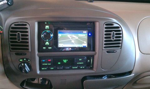 1999 Ford Expedition - The interior of a vehicle features a navigation system and climate control panel.