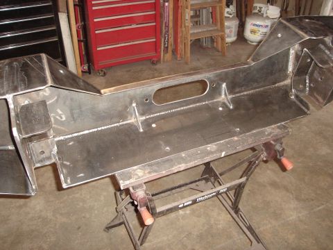 1989 Ford Bronco - A custom-fabricated steel bumper, likely for an off-road vehicle, is shown mounted on a sawhorse in a workshop setting.
