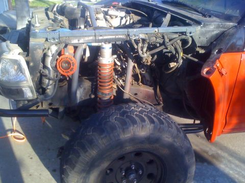 1992 Ford Ranger - This heavily modified truck shows its exposed engine and suspension components, an orange coilover and a large off-road tire.