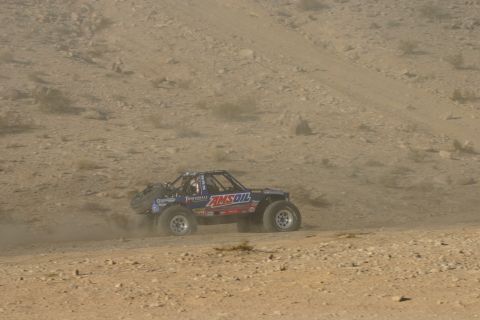 1992 Jeep Wrangler - A custom off-road buggy, sponsored by Amsoil, navigates a dusty desert terrain during a race.