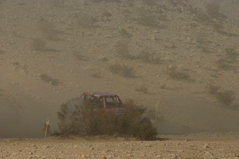 1992 Jeep Wrangler - A red off-road vehicle navigates a dusty desert course, possibly during a race event like KOH 2011.