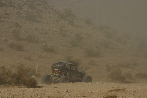 1992 Jeep Wrangler - A heavily modified off-road buggy navigates a dusty desert terrain during a race.