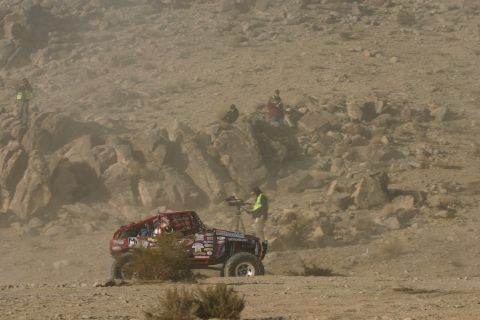 1992 Jeep Wrangler - An off-road vehicle is stopped on a dusty course, with a cameraman documenting the event.