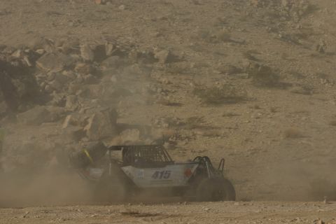 1992 Jeep Wrangler - A custom off-road buggy, marked with the number 415, navigates a dusty, rocky terrain during a race.