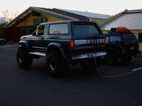 1996 Ford Bronco - A lifted green Ford Bronco is parked outside a building with "EDEN" signage.