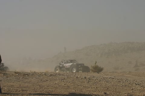 1992 Jeep Wrangler - Multiple off-road vehicles navigate a dusty, arid terrain during an event.