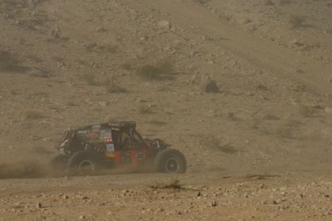 1992 Jeep Wrangler - A custom off-road buggy races across a dusty desert terrain during an event.