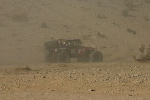 1992 Jeep Wrangler - A custom off-road buggy navigates a dusty desert terrain, kicking up dust as it moves.