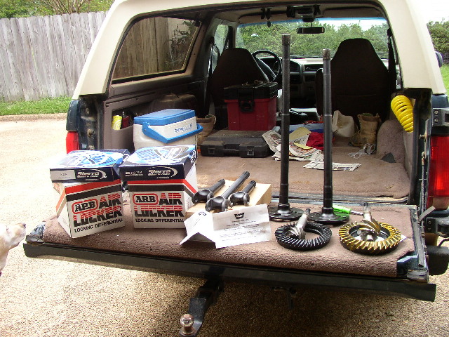 Open SUV tailgate loaded with ARB Air Locker boxes, axle shafts, and ring-and-pinion gear sets