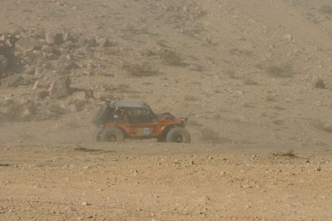 1992 Jeep Wrangler - An orange off-road buggy navigates a dusty desert terrain during an event.