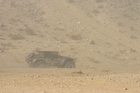 1992 Jeep Wrangler - A modified Jeep navigates a dusty off-road course, kicking up a cloud of dirt as it goes.