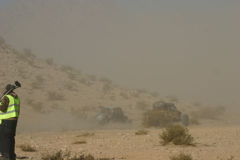 1992 Jeep Wrangler - Off-road vehicles compete in a dusty desert race event, captured by a photographer on the scene.