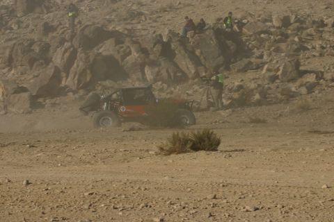 1992 Jeep Wrangler - A red off-road buggy navigates a dusty desert terrain during an event.