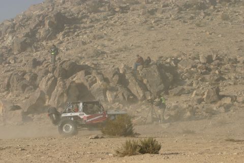 1992 Jeep Wrangler - A customized off-road buggy navigates a dusty desert terrain, possibly during a race event.